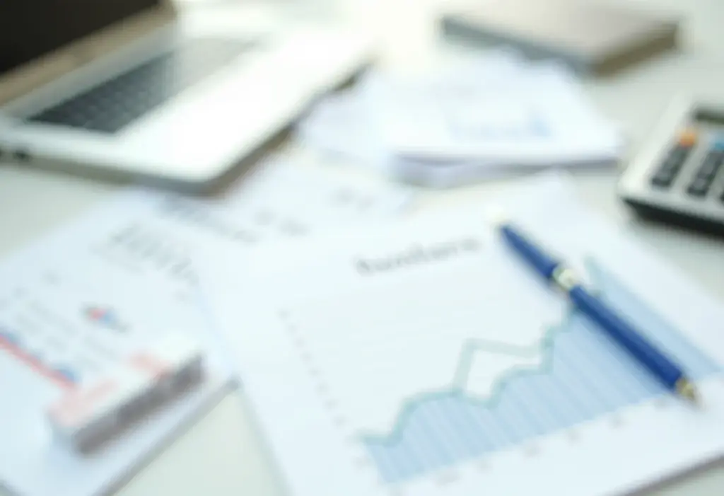 Documentos financeiros, calculadora e gráfico ascendente.